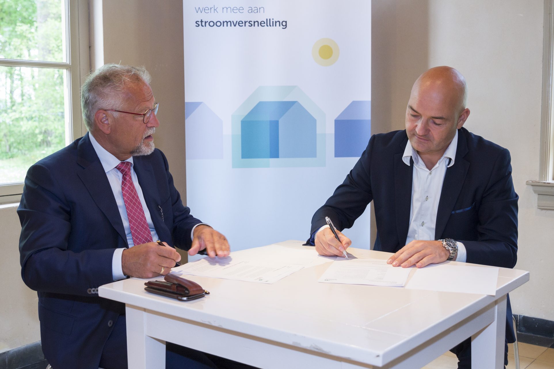 Rene Beks (rechts) en Leen van Dijke tekenen overeenkomst Stroomversnelling
